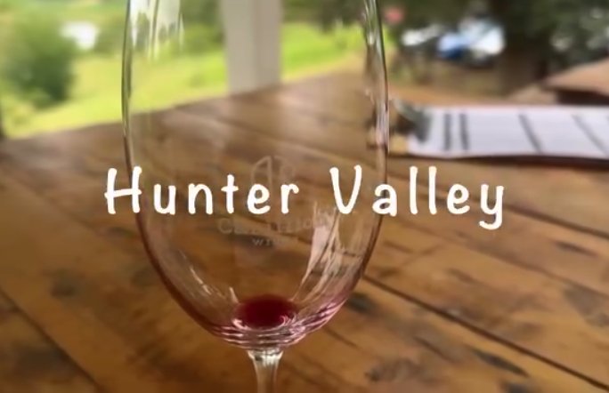 A glass of Hunter Valley red resting on a timber table at a cellar door